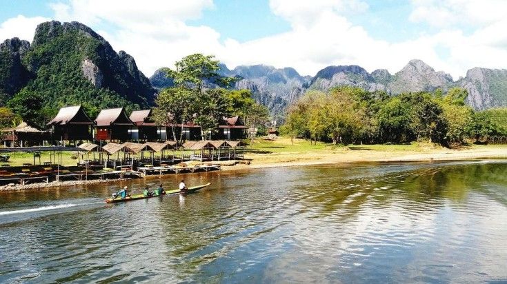 Visitors enjoy a long tail boat ride on Nam Song River in Vang Vieng, Laos. Visitors enjoy a long tail boat ride on Nam Song River in Vang Vieng, Laos.