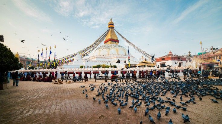 Kathmandu has plenty of attractions to keep you busy for 4 days. A view of Boudhanath Stupa in Kathmandu with a lot of pigeons.