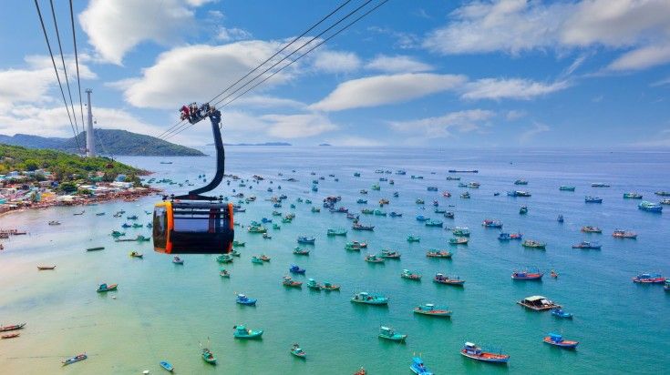 A cable car hanging above the sea with boats at Phu Quoc Island.
