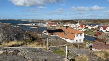 Scenic view of Vrångö island featuring rocky coastline, wooden houses & sea
