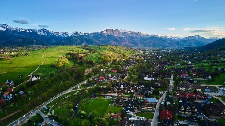 Aerial view of Tatra mountains and Zakopane town at sunset.