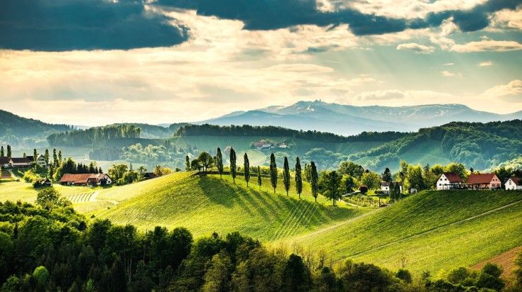 South styria vineyards with lush green trees and traditional houses near Gamlitz in Austria, one of the best places to visit in May.