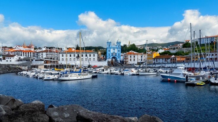 The Marina de Angra in the city of Angra do Heroísmo in Terceira Island is the gateway to sailing for activities such as whale watching and swimming with the dolphins. View of the marina of Angra and the church of Mercy in Terceira Island