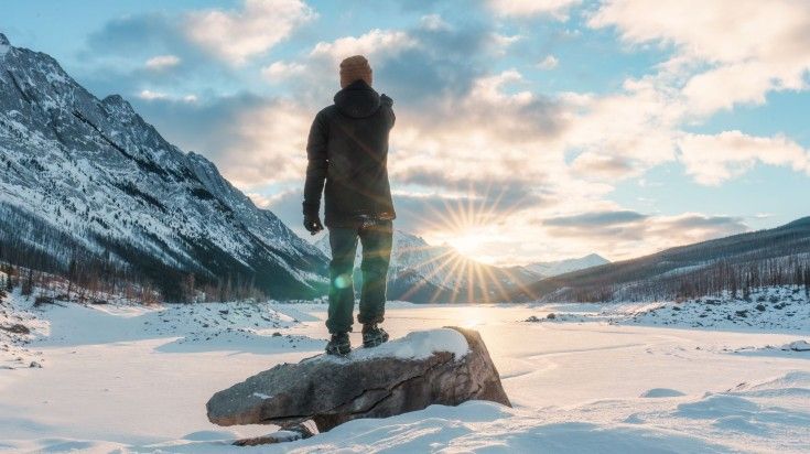 A man standing in frozen lake at Medicine Lake