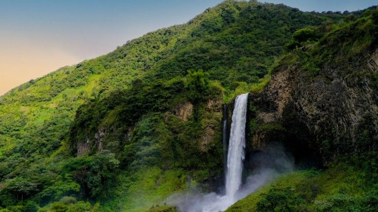 The view of Banos Waterfall during sunset in Ecuador.