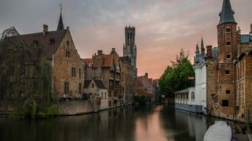 Canals in Bruges, Belgium flows between old houses and buildings