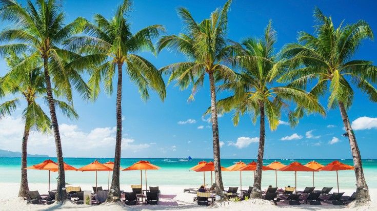 Beach loungers chairs and umbrella on tropical Borocay island on a sunny da