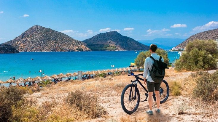 A tourist man with his bicycle admiring the view of Tolo during his 8 days