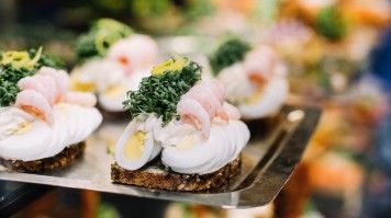 At their simplest, smørrebrød are open-faced sandwiches built on a thin layer of dense sourdough rye bread. A traditional open Danish sandwich is a must-eat during a visit to Denmark