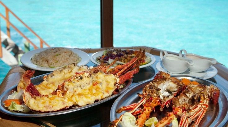 Two plates with lobsters on the table.