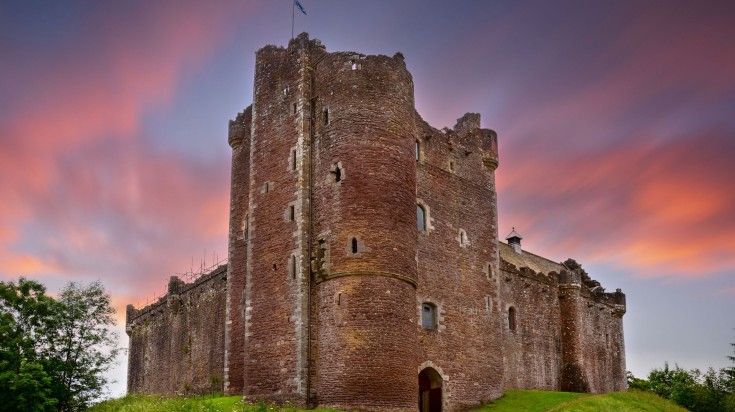 A sunset illuminates Doune Castle in the Stirling district of Scotland.