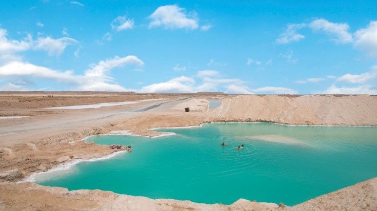 People take a break swimming in the  lake in Siwa oasis