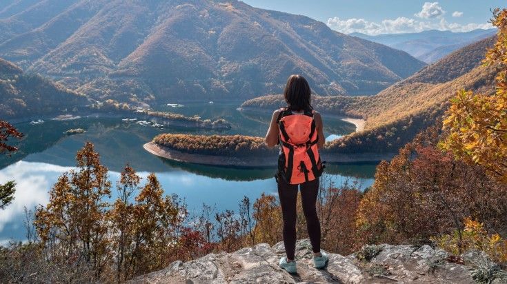 Female backpacker taking in the view of the Lake Vacha Reservoir.