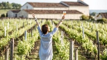 Woman with wine in hand in a vineyard in Bordeaux, France