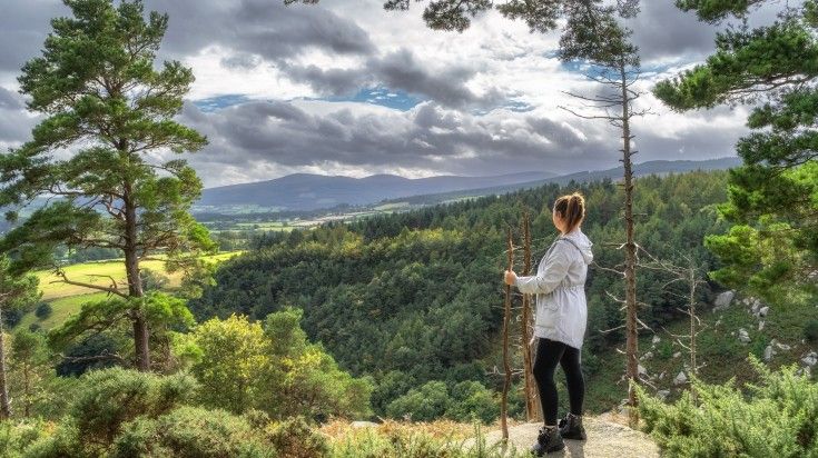 A girl hiker admiring the beauty from the Wicklow Mountain on a cloudy day.