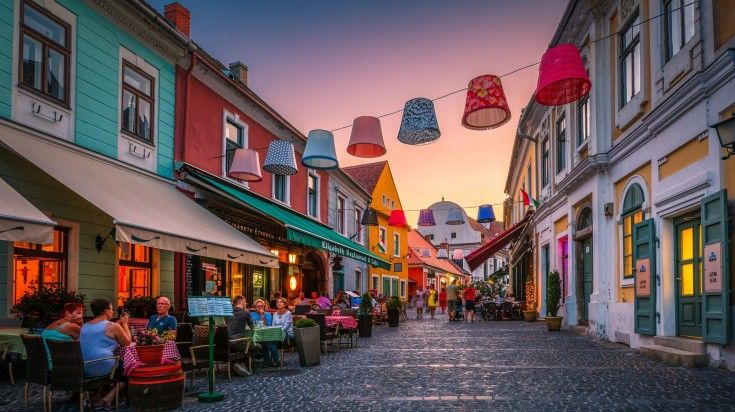 Szentendre is a charming town near Budapest, known for its rich cultural heritage, stunning baroque architecture, and vibrant arts scene, making it a must visit while in Hungary. Visitors in restaurants and cafés in the historic old town of Szentendre.