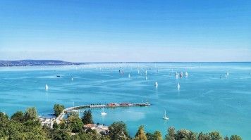 Lake Balaton offers stunning views and activities like swimming in its warm waters and hiking the scenic trails around the lake. The stunning blue waters of Lake Balaton in Hungary.