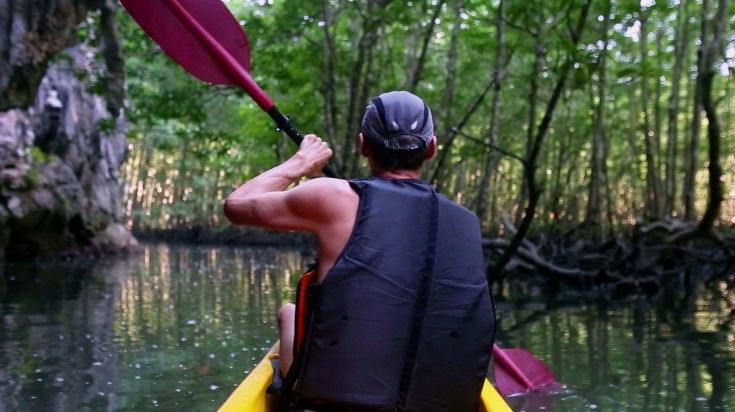 A man kayaking in Mae Tae River in Thailand. A man kayaking in Mae Tae River in Thailand.
