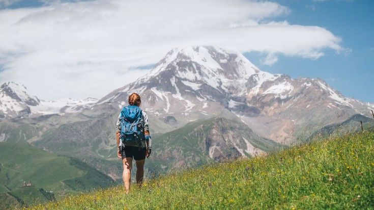 A hiker admiring the view of Mount Kazbek on an early morning during her one week in Georgia. A hiker admiring the view of Mount Kazbek on an early morning