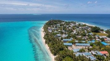 the island of Dhigurah in the Maldives surrounded by blue water