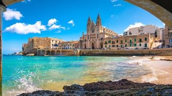 Spend a blissful free day on the stunning beaches of Sliema, Malta, and soak up the sun and sea during your unforgettable 12-day Italian adventure. View of Saint Julian beach on a sunny day in Malta.