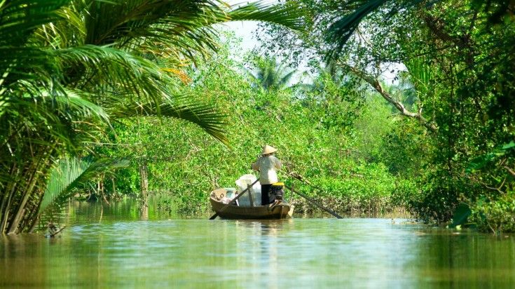 A woman driving boat in Mekong River on a clear day.
