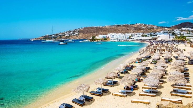 Beautiful sand beach with chairs in Mykonos on a sunny day.