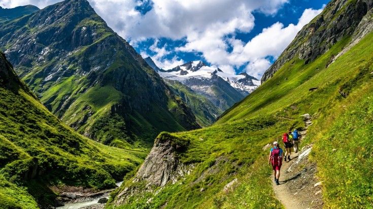 People hiking in Hohe Tauern National Park on a cloudy day in Austria.