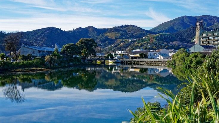 Panorama of Nelson City, reflected in the still waters of the Maitai River.