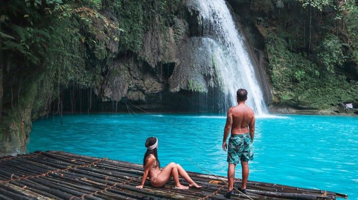 A couple in the wooden raft in Kawasan Falls in the Philippines.