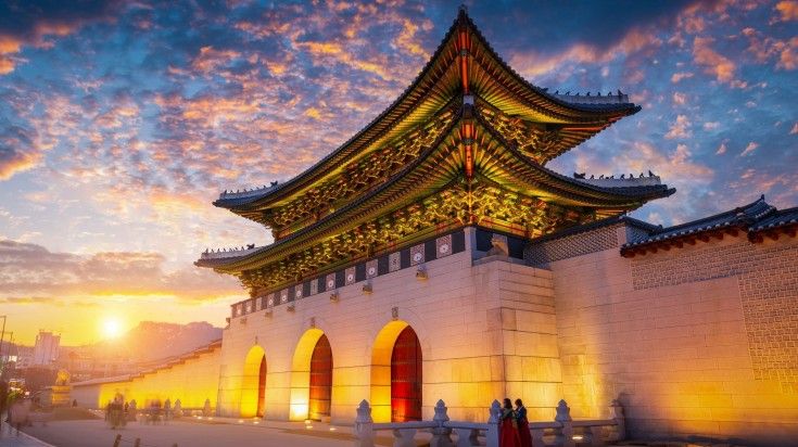 A view of Gyeongbokgung Palace during sunset under a cloudy sky in South Korea.