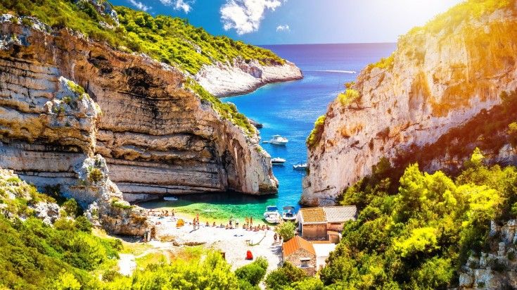 Scenic Stiniva Beach on island of Vis with sun haze view in Croatia.