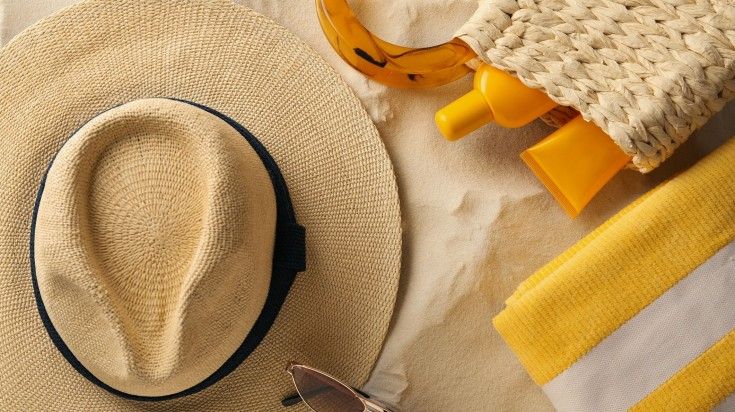 Sunscreen, straw hat and sunglasses on the table. Sunscreen, straw hat and sunglasses on the table.