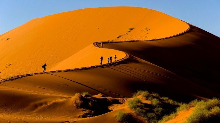 Tourists climbing Sossusvlei Dune in Naukluft National Park.