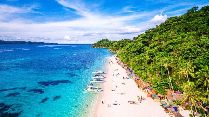 Tourists in the shores of Puka beach in Boracay Island.