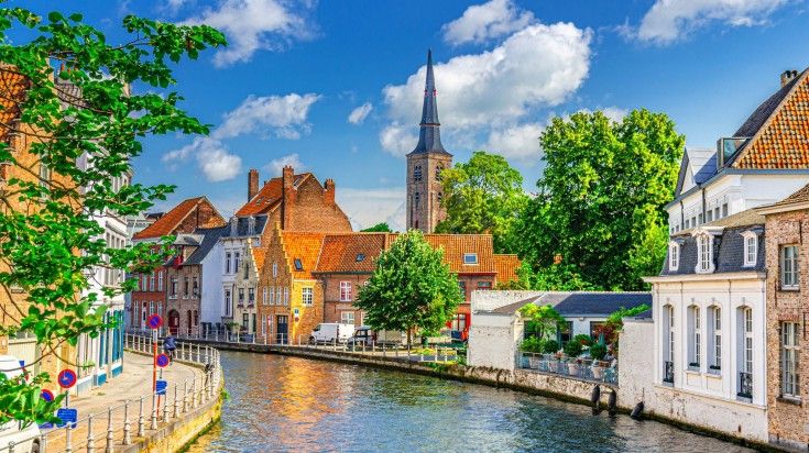 Sint Annarei water canal of Reie river with old buildings on embankment in Brugge old town in Belgium in June.