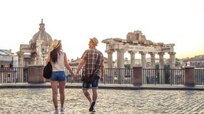 A happy couple walking hand in hand towards Roman Forum, one of the best places to visit in Italy.
