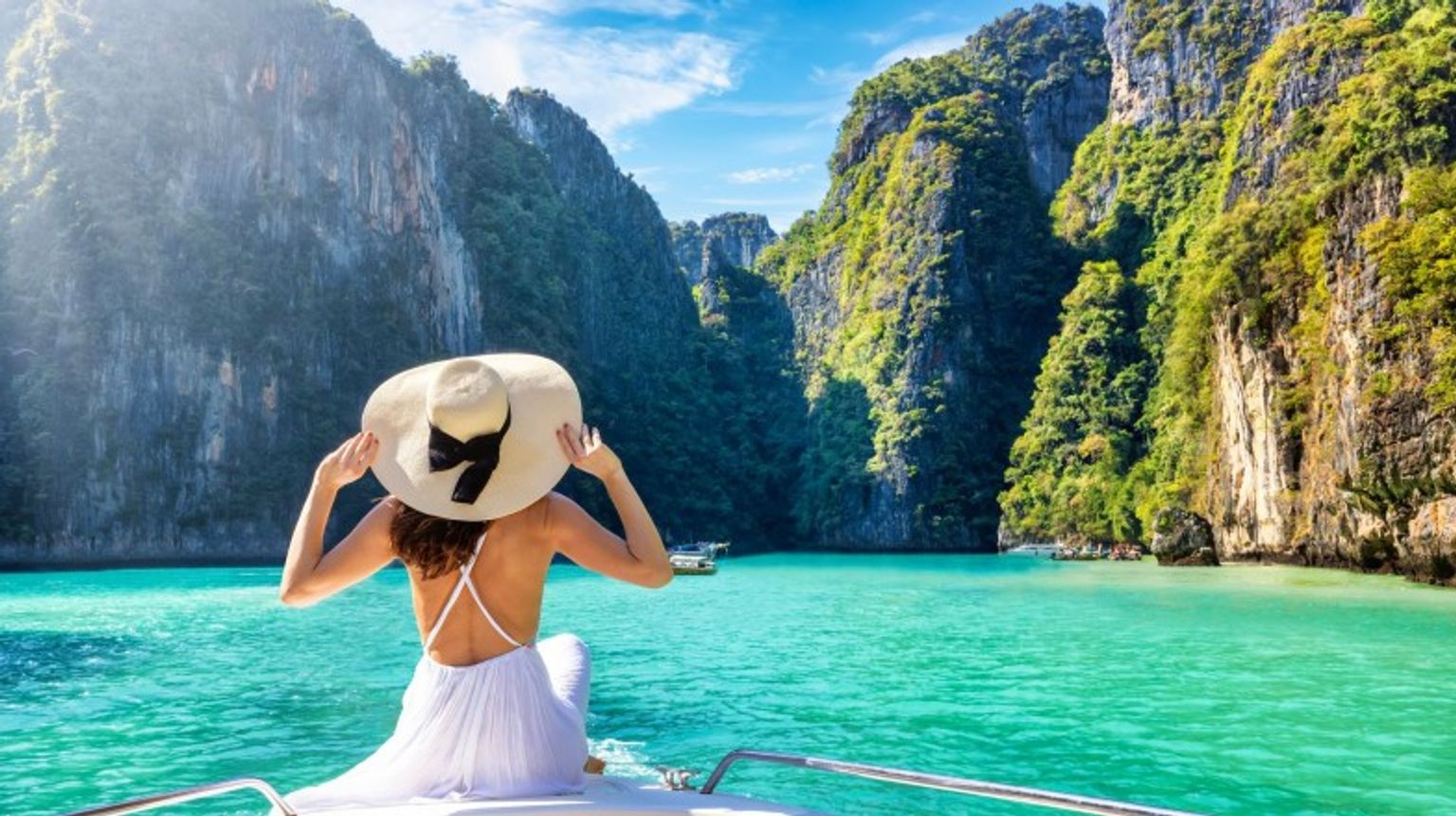 A girl in the white dress relaxing on a boat in Maya beach during her 10 days in Thailand.
