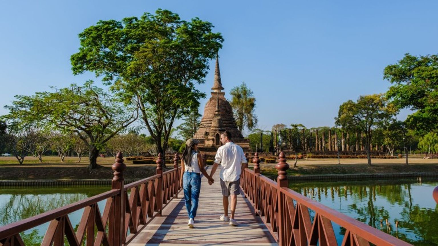 A couple walking hand in hand in Sukhothai during their 11 days in Thailand.
