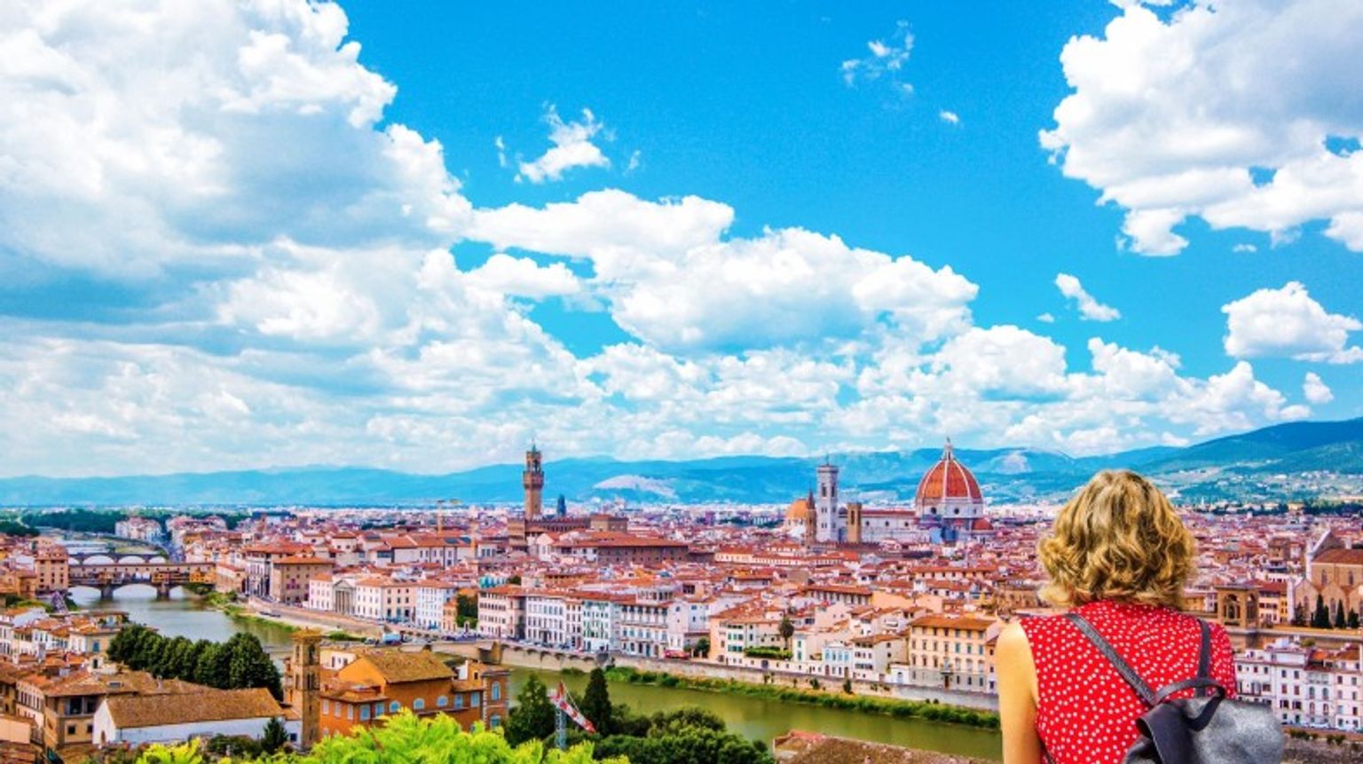 A woman tourist admires Florence from Piazzale Michelangelo's top view during her 12 days in Italy.