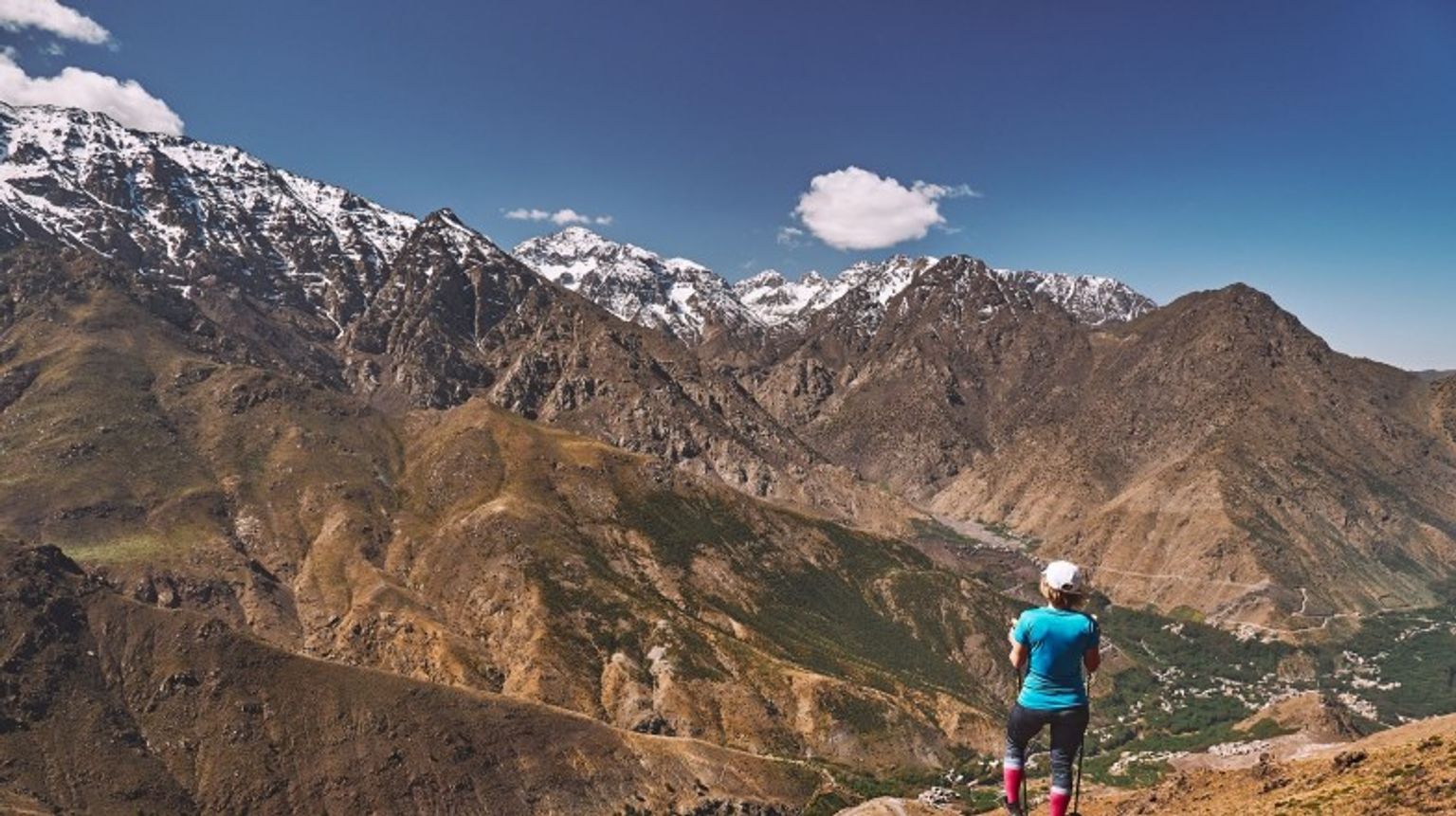Admire the breathtaking Atlas Mountains during your 12 days in Morocco, where stunning landscapes and vibrant Berber culture await you at every turn. A girl admiring the beauty of Atlas Mountain during her 12 days in Morocco.
