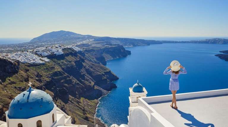 A young woman looks at the marine landscape of Santorini during her 13 days in Greece.