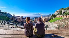 A couple admiring the view of Greek theatre in Taormina during their 2 weeks in Italy.