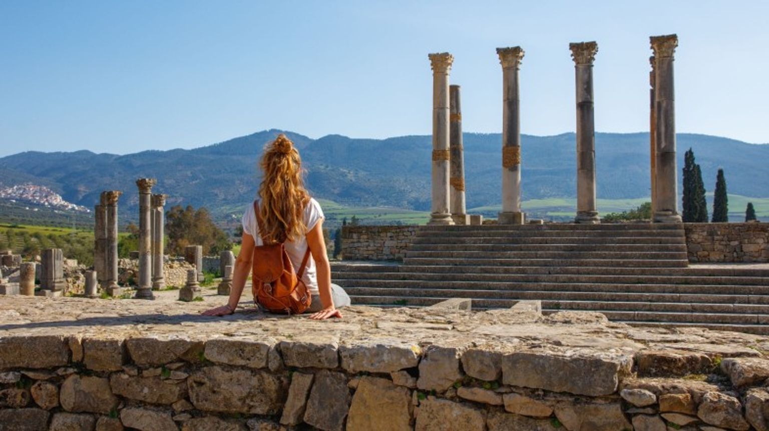 A woman tourist relaxing in Volubilis on her 2 weeks in Morocco.
