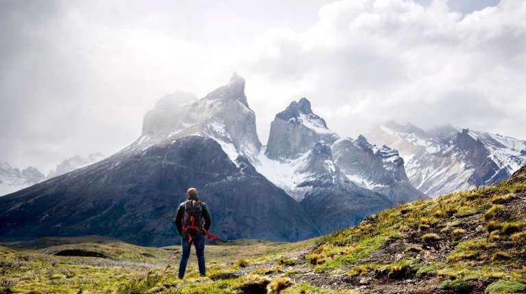 A man admiring the beauty of Torres del Paine on a cloudy day during his 4 days in Patagonia.