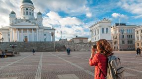 A woman with camera on Senate Square in Helsinki during her 5 days in Finland trip.