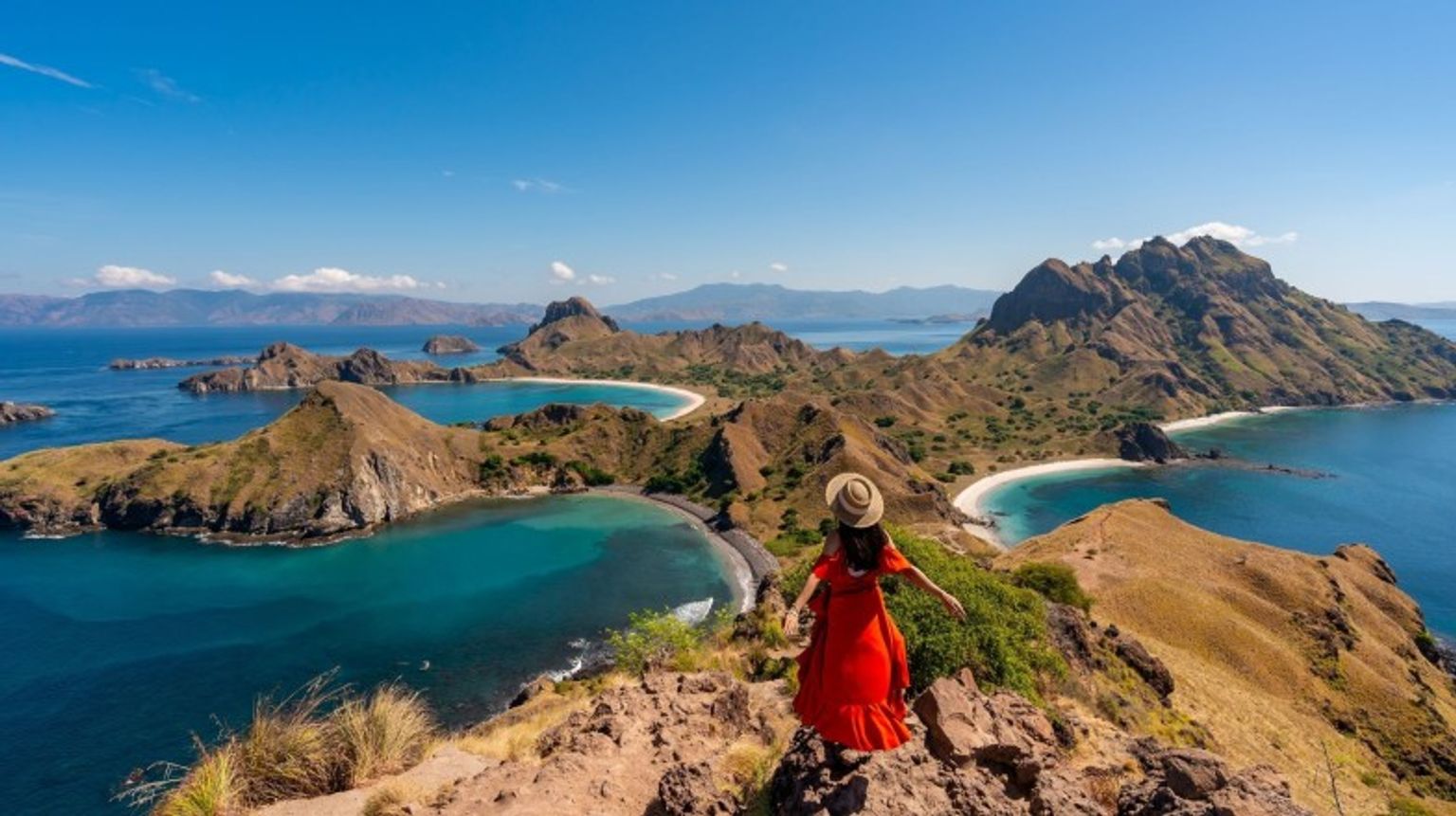 Explore the breathtaking Komodo National Park during your 12 days in Indonesia, where you can witness the legendary Komodo dragons. A young girl on Padar Island In Komodo National Park during her 12 days in Indonesia.