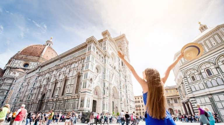 A tourist girl raising hands near Santa Maria del Flore Church in Florence during her 8 days in Italy.
