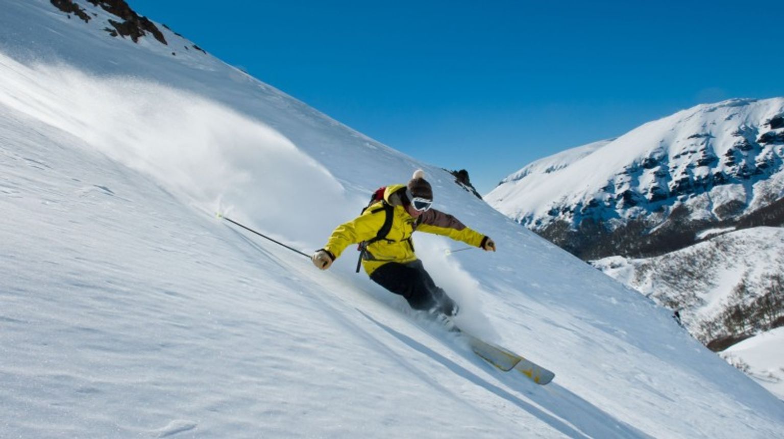 Hit the slopes and ski in the stunning Andes of Argentina in June, where world-class resorts, and breathtaking mountain views. A man skiing in Andes in Argentina in June.