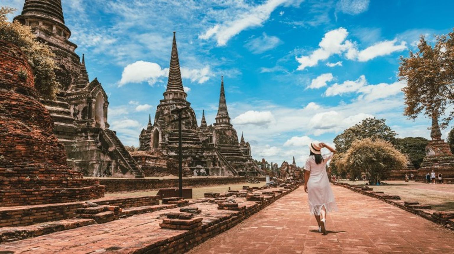 A tourist woman exploring Wat Phra Si Sanpet temple at Ayutthaya Historical Park on a cloudy day during her 9 days in Thailand.